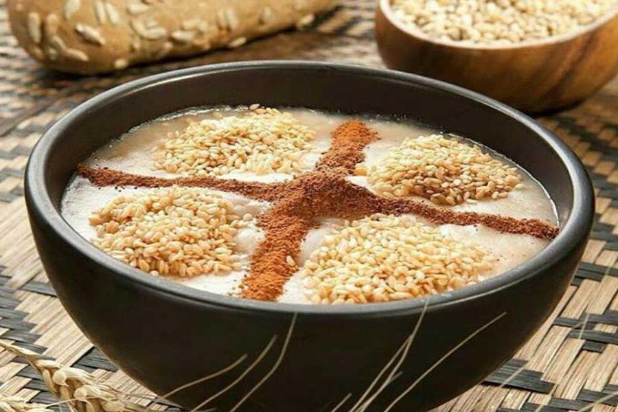 یک ظرف حلیم تزئین شده با کنجد و دارچین