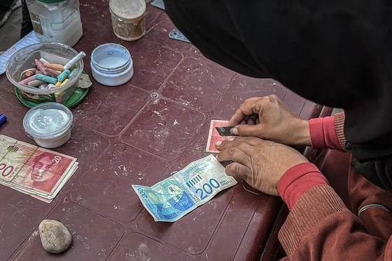 گزارش تصویری | زن فلسطینی با ترمیم اسکناس‌های پاره امرار معاش می‌کند