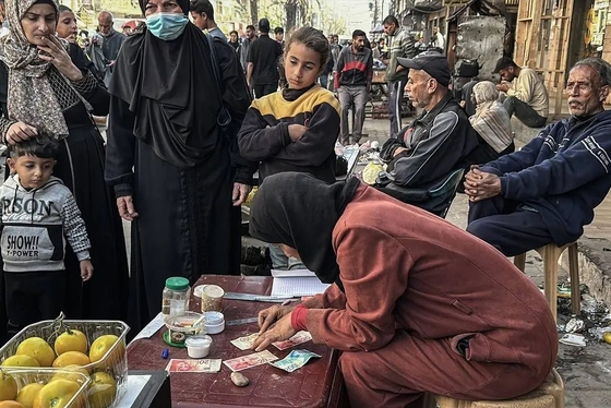 گزارش تصویری | زن فلسطینی با ترمیم اسکناس‌های پاره امرار معاش می‌کند