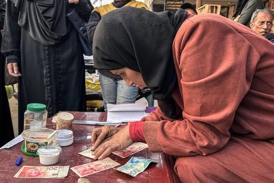 گزارش تصویری | زن فلسطینی با ترمیم اسکناس‌های پاره امرار معاش می‌کند