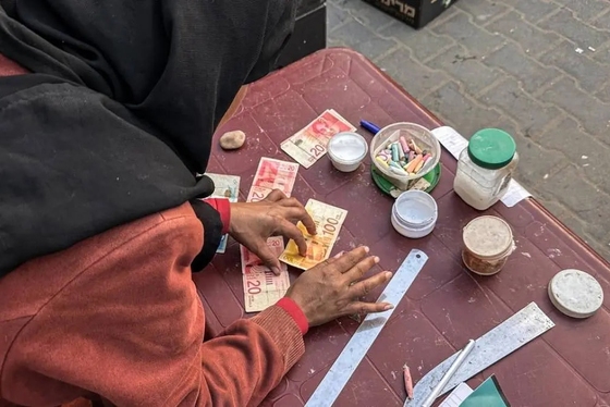 گزارش تصویری | زن فلسطینی با ترمیم اسکناس‌های پاره امرار معاش می‌کند