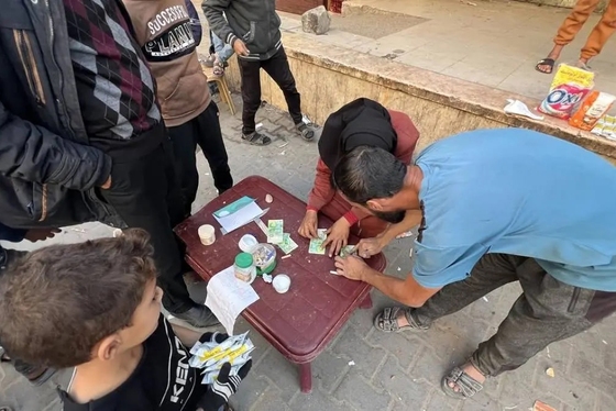 گزارش تصویری | زن فلسطینی با ترمیم اسکناس‌های پاره امرار معاش می‌کند