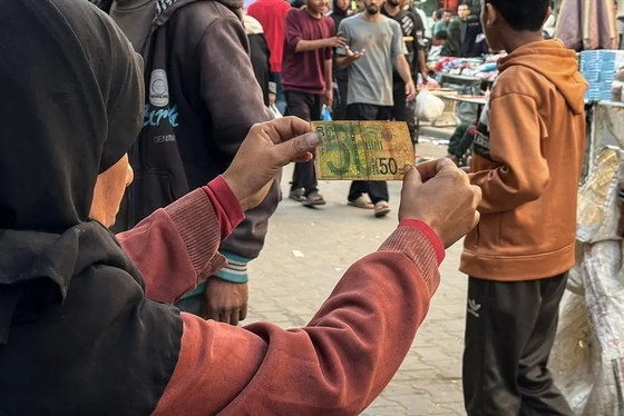 گزارش تصویری | زن فلسطینی با ترمیم اسکناس‌های پاره امرار معاش می‌کند