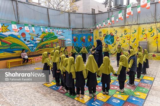 مهری پارسی، 36 ساله ، معلم پایه اول دبستان، در زنگ تفریح با دانش اموزان خود بازی می کند.