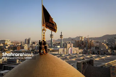 اهتزاز پرچم عزای حسینی بر فراز گنبد حرم رضوی