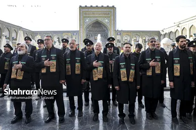 خادمان در حال اذن گرفتن از امام رضا(ع) برای شروع این آیین هستند
