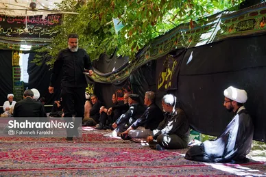 خادم حسینیه در حال پذیرایی از مهمانان است