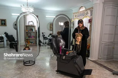ناهید فروتن ، 39 ساله ، آرایشگر، در حال تمرین کوتاهی مو روی سر مانکن است.