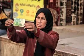 گزارش تصویری | زن فلسطینی با ترمیم اسکناس&zwnj;های پاره امرار معاش می&zwnj;کند