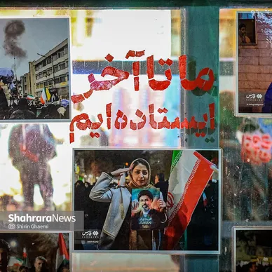 «ما تا آخر ایستاده ایم »نشان از شعار مردمی دارد که تا روز پیروزی حامی دولت و نیروی نظامی کشور است . بر روی شیشه های ایستگاه میدان شریعتی شهر مشهد در کنار عکس هایی از مردم در تجمعات شبانه . 