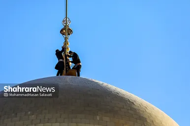 اهتزاز پرچم عزای حسینی بر فراز گنبد حرم رضوی