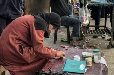گزارش تصویری | زن فلسطینی با ترمیم اسکناس‌های پاره امرار معاش می‌کند
