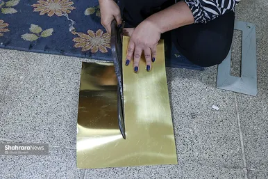 یکی از کارگران در حال برش ورق به ابعاد کوچکتر برای استفاده سر سماور 
