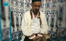 گربه&zwnj;ای که با امام جماعت در حال تلاوت قرآن بازی می&zwnj;کند + فیلم