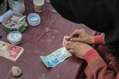 گزارش تصویری | زن فلسطینی با ترمیم اسکناس‌های پاره امرار معاش می‌کند