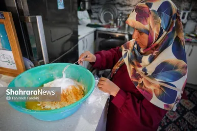 عروس فاطمه خانم در حال آماده سازی محتویات خمیربرای آماده سازی نان است.