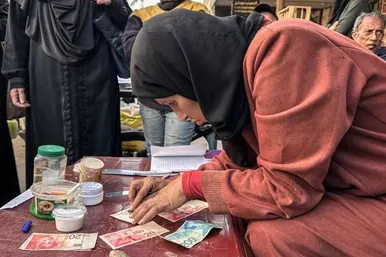 گزارش تصویری | زن فلسطینی با ترمیم اسکناس‌های پاره امرار معاش می‌کند