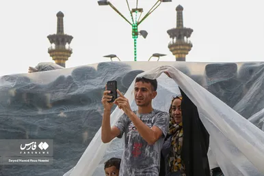 دعا و نیایش زائران زیر باران شدید در حرم امام رضا(ع)
