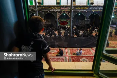 کودکی از طبقه بالا در حال تماشای حسینیه است