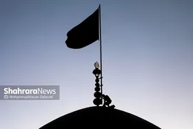 اهتزاز پرچم عزای حسینی بر فراز گنبد حرم رضوی
