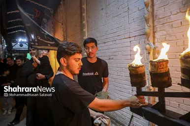 خادمان هیئت تجهیزات آیین را برای حرکت دسته عزا مهیا می کنند.