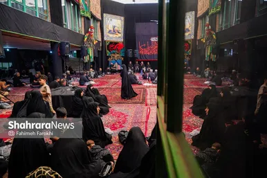 حاضران در حسینیه در حال گوش دادن به سخنرانی هستند